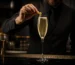 Bartender decorando un cóctel French 75 con limón